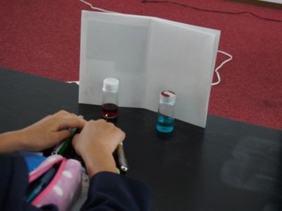 赤と青の溶液にレーザーを当てる実験